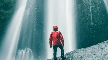 Mies vesiputouksen vieressä